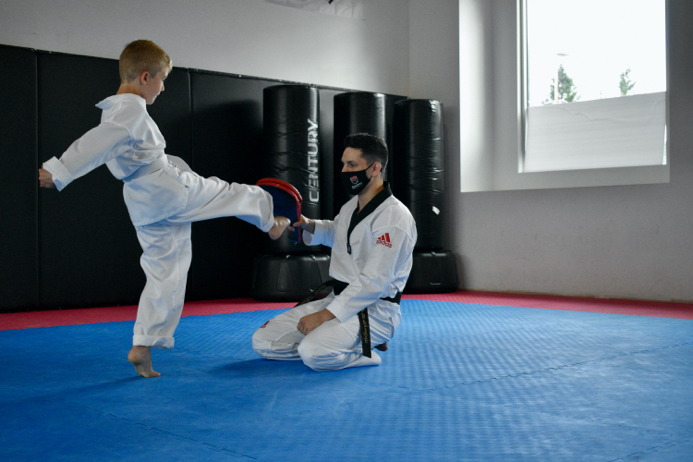 Marco of Black Rock Martial Arts teaches young students how to perform accurate taekwondo kicks.