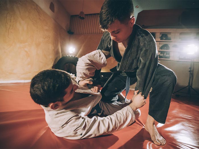 A child martial arts student is seen smiling and in a taekwondo stance.