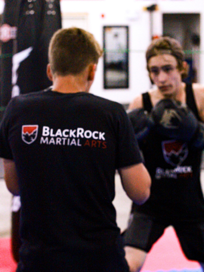 Two kickboxing students prepare to spar with each other.